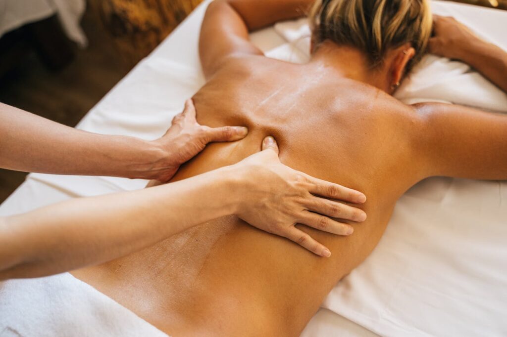 Close-up of a relaxing massage therapy session at a spa with focus on back and hands. Prenota un Massaggio